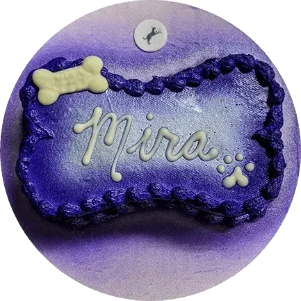 Purple bone-shaped cake with "Mira" icing.