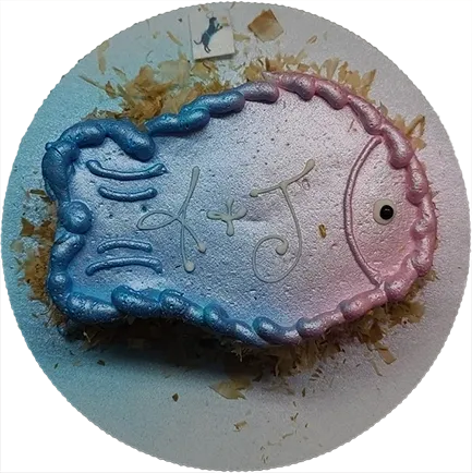 Fish-shaped cake with initials and decorations.