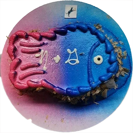 Colorful fish-shaped cake with icing details.