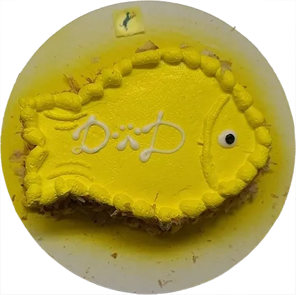 Yellow fish-shaped cake with decorative icing.