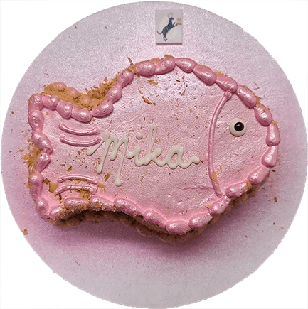 Fish-shaped pink cake with "Mika" decoration.
