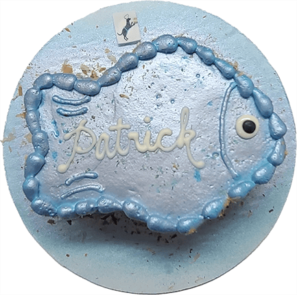 Fish-shaped blue cake with name decoration.