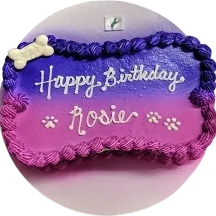 Purple-pink birthday cake with dog bone decoration.