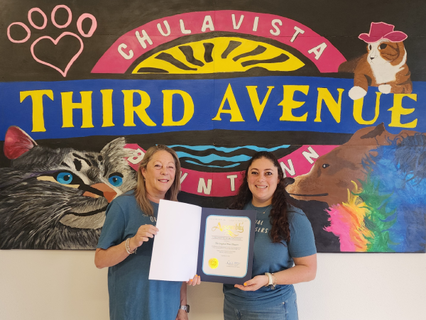 Two women holding a certificate, smiling.