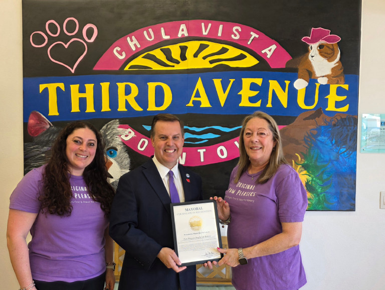 Three people holding a certificate, smiling.