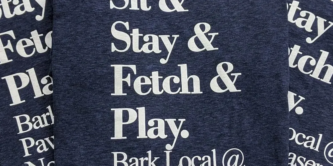 Shirt featuring dog commands in white text.