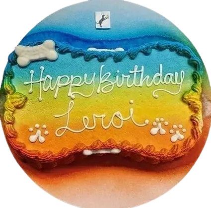 Colorful dog birthday cake with bone decoration.