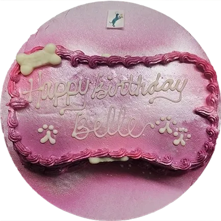 Pink dog-themed birthday cake with bone decoration.
