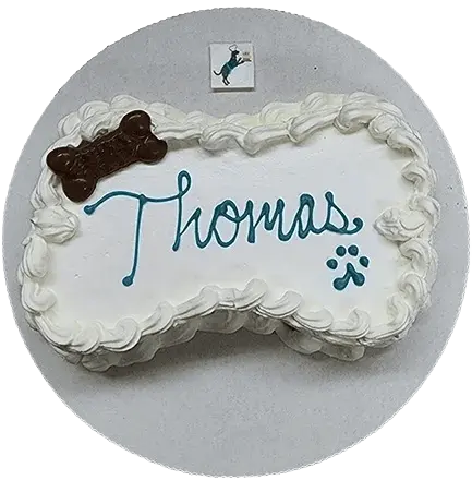 Bone-shaped cake with "Thomas" and paw print.