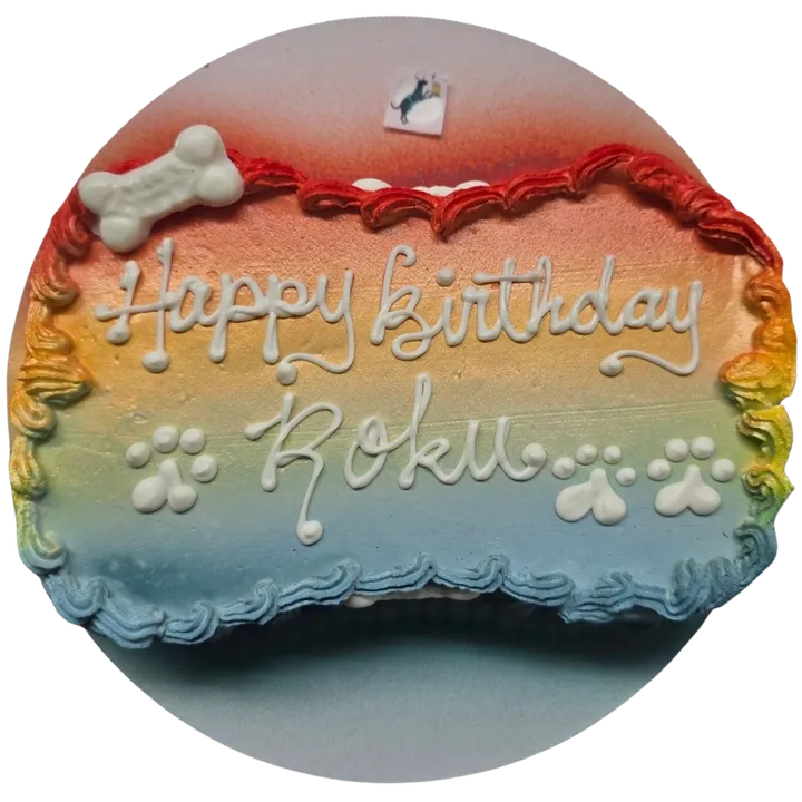 Colorful dog birthday cake with paw prints.